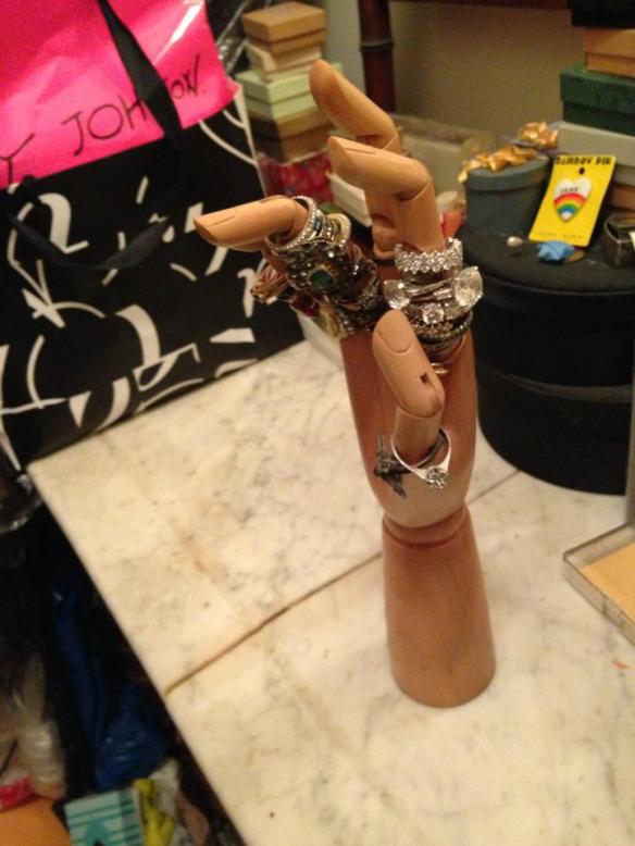 Wooden hand covered in old costume jewelry.