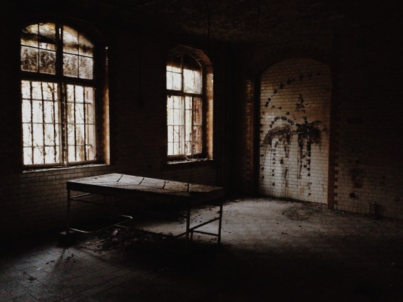 An old operating table with grooves to let bodily fluids (i.e. blood) leak down