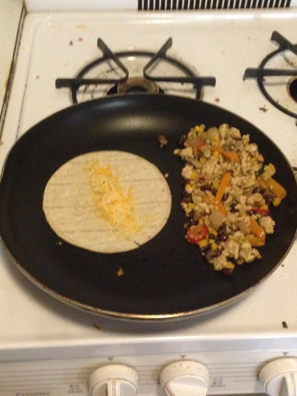 Clear the pan (or use a new one). Take a corn tortilla and cook it on one side for a minute or so before flipping. Add cheese and cook until the other side starts to brown and the cheese begins to melt.